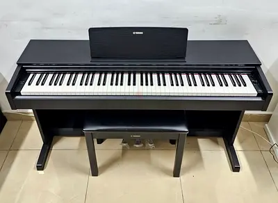 The Yamaha Arius YDP-103B is an 88-key, entry-level digital console piano featuring a black finish,