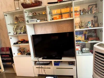 White wooden entertainment center with display cabinets and TV unit