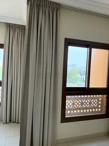 Pair of beige fabric blackout curtains with pleated header - like new
