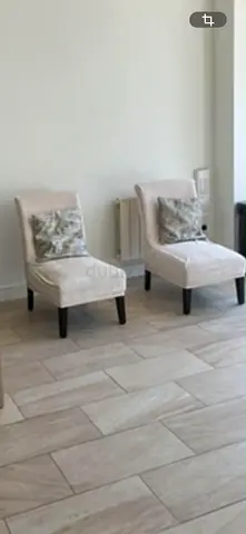 Pair of beige armless accent chairs without cushions