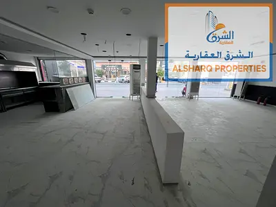 Shop for annual rent in Al-Rashidiya 1, next to Ramada Park Hotel, available in a prime location with ample space.