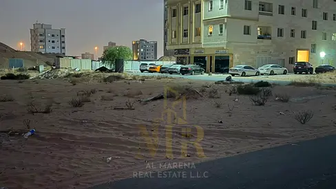 A corner residential/commercial plot of land in Al Alia, Ajman, measuring 4,350 sq ft, with a building permit for a ground floor (G+4), priced at AED