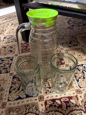 Glass water jug with two matching glasses, green lid