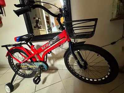 Red kids bicycle with training wheels and front basket - good condition