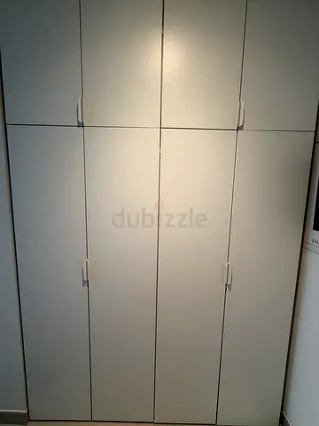 White IKEA built-in wardrobe with shoe shelves and hanging space - perfect condition.