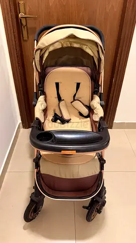 Lightly used beige-brown baby stroller/pram with harness and storage
