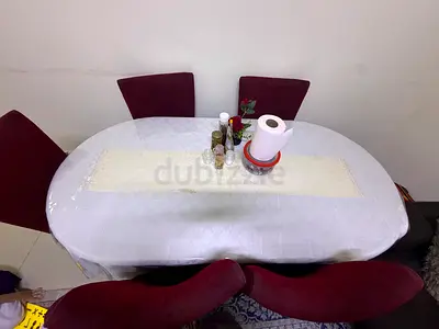 Oval dining table with 5 red upholstered chairs - good condition