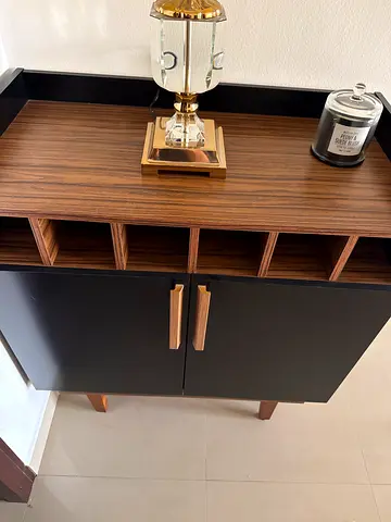 Compact black and wood side cabinet with wine rack storage.