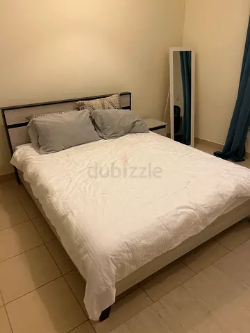 Queen wood bed frame with mattress and bedding