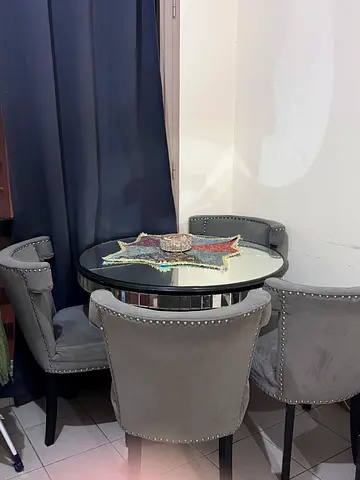 Compact round dining set with 2 grey upholstered chairs and glass table