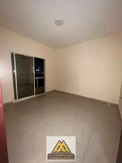 2BR in Al Nuaimiya 1, Ajman, 2 baths, balcony, separate kitchen, central AC, AED 31K, 4 payments.
