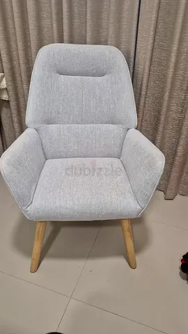 Light grey upholstered lounge chair with wooden legs