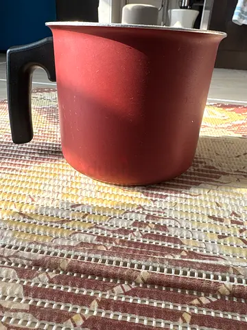 Small red stovetop kettle with black handle - used