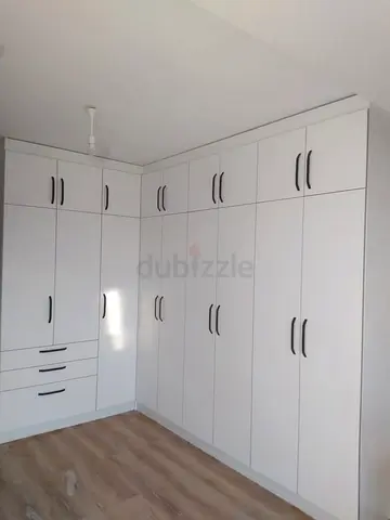L-shaped white built-in wardrobe with drawers — excellent condition