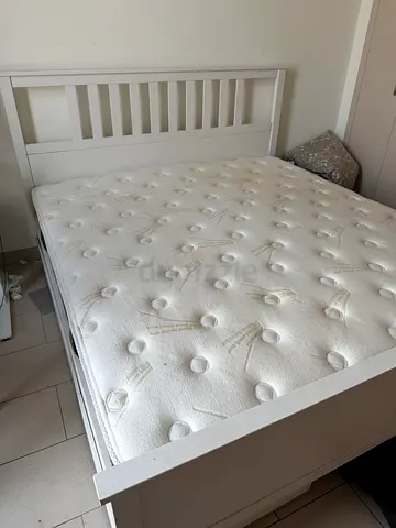 White wooden double bed frame with mattress