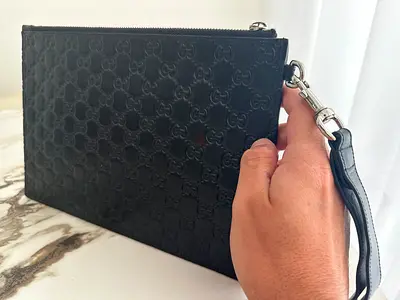 Black Gucci embossed leather wristlet clutch
