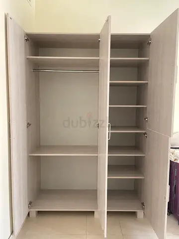 Three-door freestanding wardrobe with multiple shelves and hanging rail - light wood