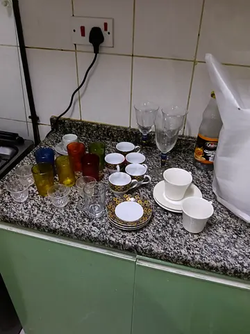 Mixed glassware and small china set — cups, saucers, glasses (used)