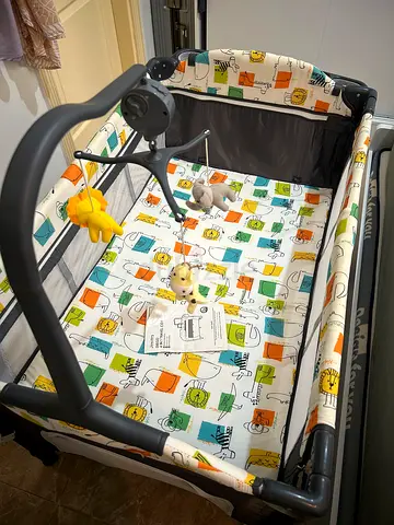 Juniors Baby Crib - Travel Cot with mattress and toy mobile — good condition