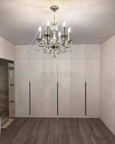 Built-in floor-to-ceiling white wardrobe with long black handles
