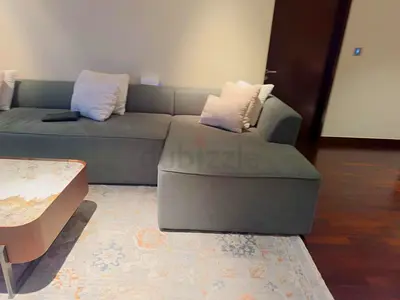 L-shaped green fabric sofa with chaise