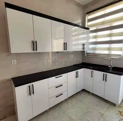 Modern White L-shaped Kitchen Cabinets with Black Countertop