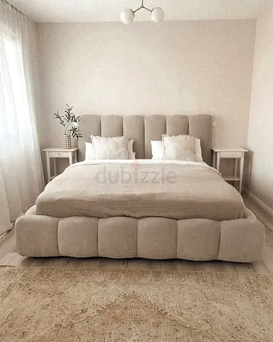 Beige upholstered queen bed with padded headboard