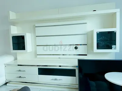 White modern TV entertainment unit with wall-mounted cabinets