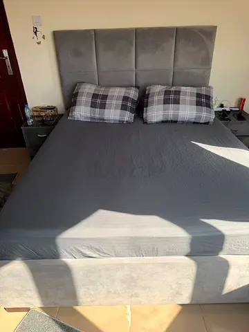 Grey upholstered double bed with headboard and storage base