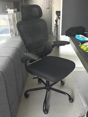 Ergonomic black mesh office chair with armrests and caster wheels
