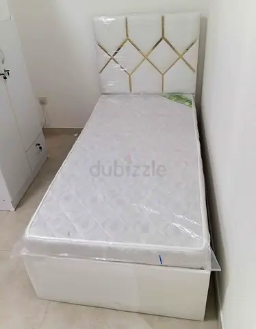 Single bed with mattress and upholstered headboard