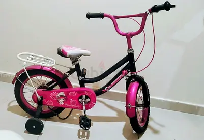 Kids pink girls bicycle with training wheels – 12-inch, good condition need to tight the chain.