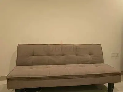 Beige 3-seater sofa bed / futon requiring repair.