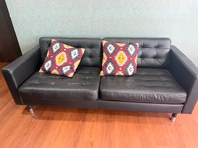 Black leather 2-seater sofa in good condition with coffee table