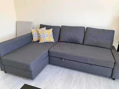 Grey L-shaped sofa bed with storage — good condition