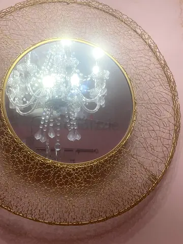 Round gold decorative wall mirror with intricate wire frame
