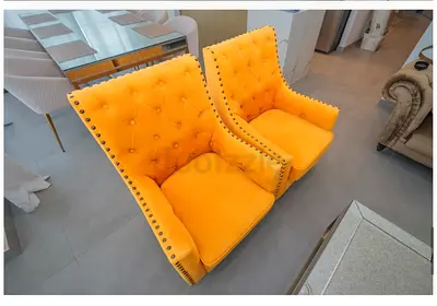 Pair of mustard yellow tufted accent armchairs with nailhead trim