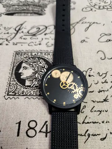 Men's black mechanical-style wristwatch with visible gold gears