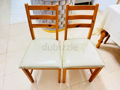 Pair of beige upholstered dining chairs with wooden legs - used