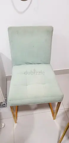 Light green upholstered dining chair with gold legs