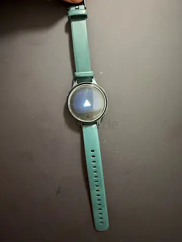 Used round-screen smartwatch with green silicone strap
