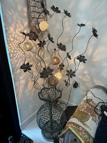 Decorative metal floor lamp with floral branches and woven base