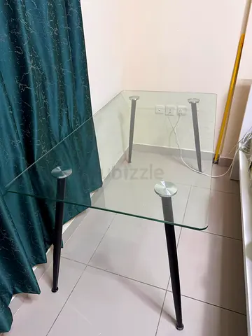 Glass Dining Table – AED 300  Elegant rectangular glass dining table with a modern black metal frame