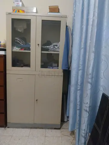 Metal storage cabinet with glass doors and drawers