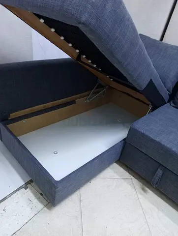 Grey fabric L-shaped sofa bed with storage