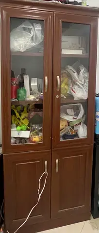 Tall wooden storage cabinet with glass doors — good condition