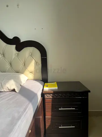 Dark wood queen bed frame with tufted cream headboard, two side table and dressing table