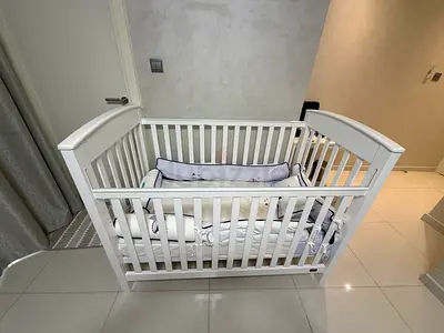 White wooden baby crib with bedding