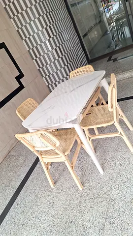 White oval dining table with 4 rattan cane chairs