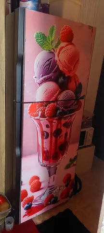 Large double-door refrigerator in working condition with decorative front